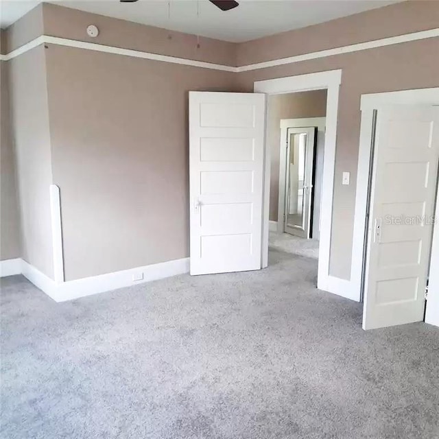 unfurnished bedroom featuring ceiling fan and light carpet