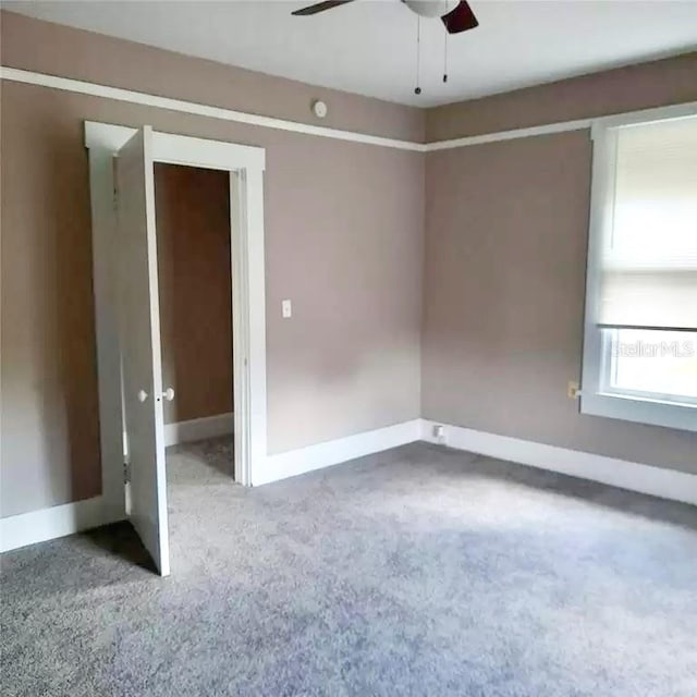 spare room featuring ceiling fan and carpet floors