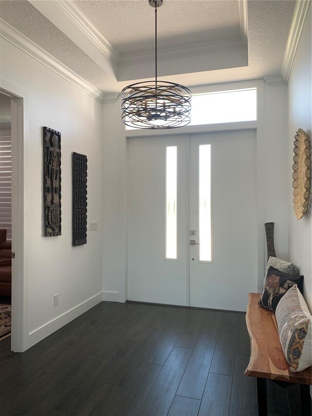 foyer with a notable chandelier, dark hardwood / wood-style floors, a textured ceiling, and a tray ceiling