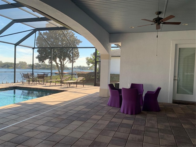 view of patio / terrace featuring a water view, ceiling fan, and a lanai