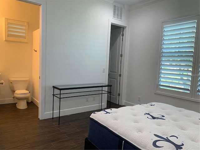 bedroom with ensuite bathroom, dark hardwood / wood-style floors, and ornamental molding