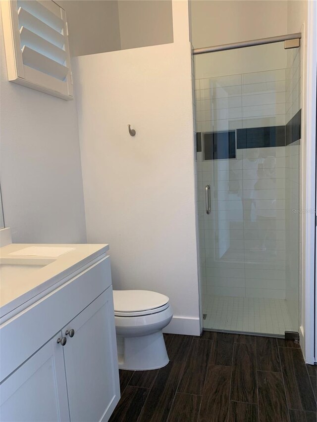 bathroom featuring vanity, toilet, and walk in shower