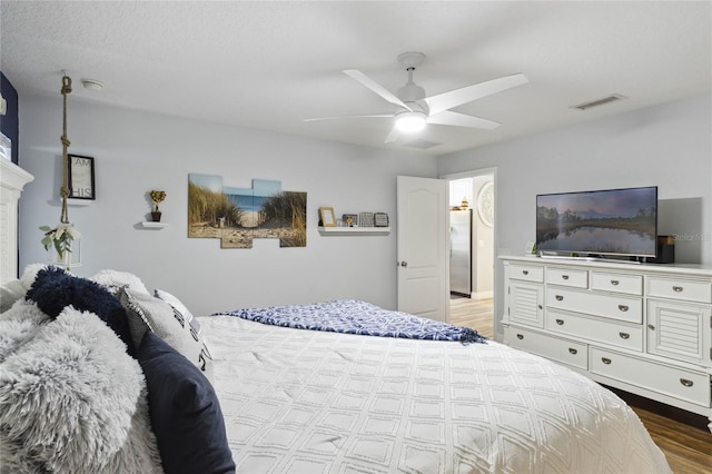 bedroom with a fireplace, ceiling fan, and light hardwood / wood-style floors