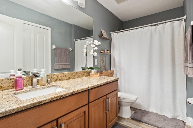 bathroom with hardwood / wood-style floors, vanity, and toilet