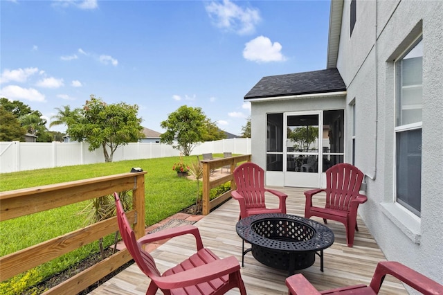 wooden terrace featuring an outdoor fire pit and a yard