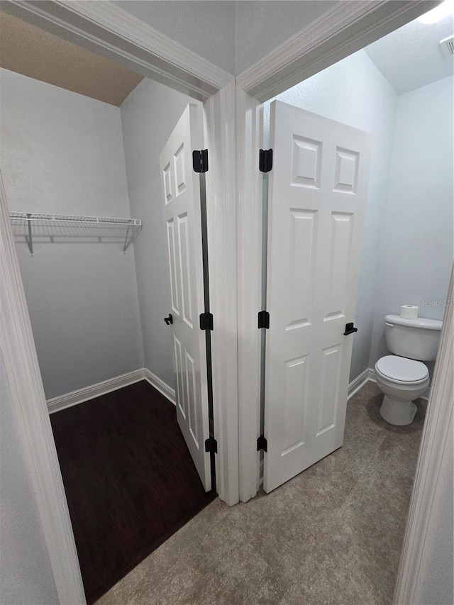 bathroom featuring toilet and wood-type flooring