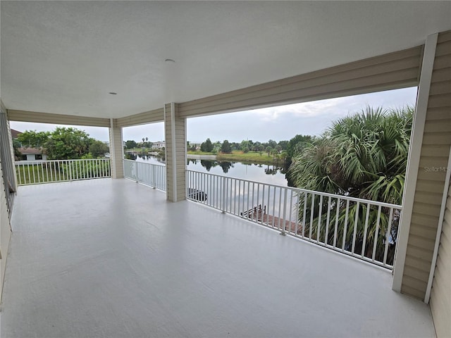 view of patio featuring a balcony and a water view