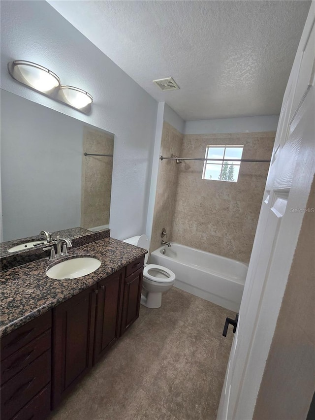 full bathroom featuring tiled shower / bath, vanity, toilet, and a textured ceiling