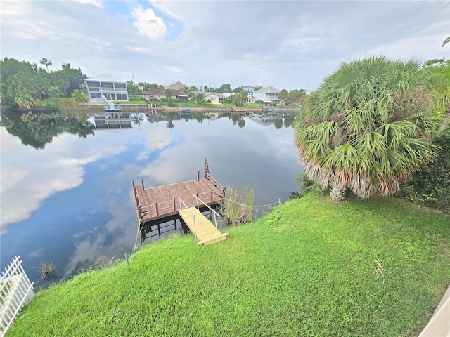 view of dock featuring a water view and a yard