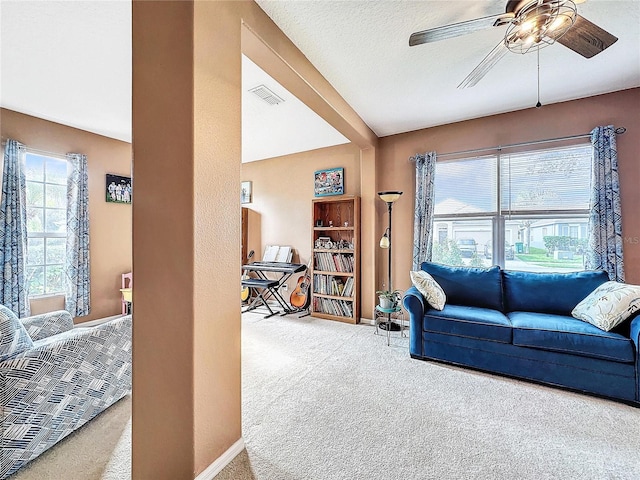 carpeted living room with ceiling fan and a textured ceiling