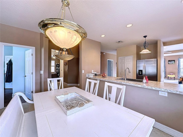 dining area with a textured ceiling and sink