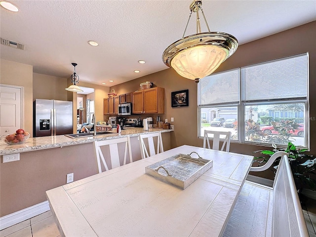 tiled dining space with a textured ceiling and sink