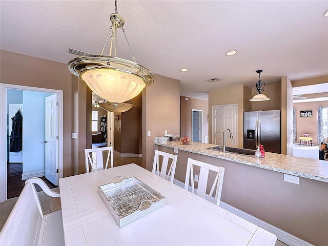 dining area with a textured ceiling and sink