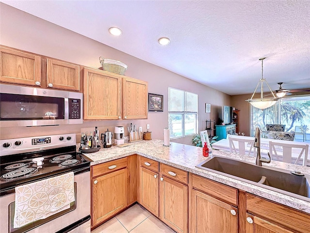 kitchen featuring a textured ceiling, sink, stainless steel appliances, light tile patterned floors, and ceiling fan