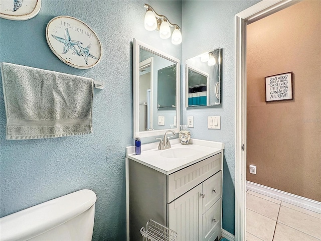 bathroom with vanity, toilet, and tile patterned floors