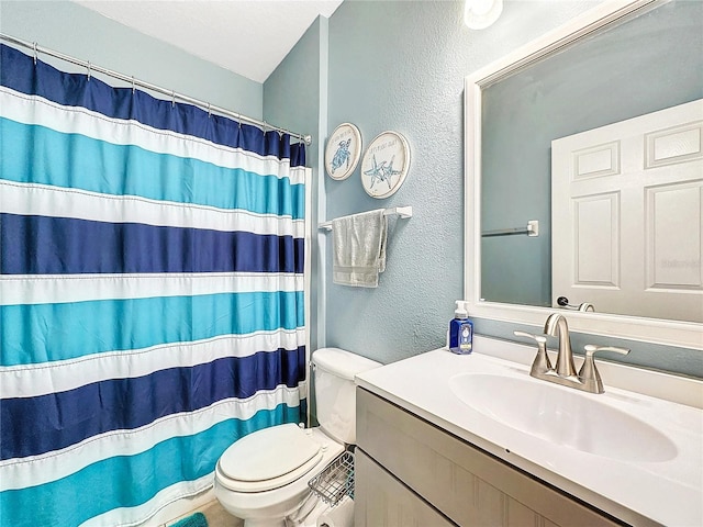 bathroom with walk in shower, vanity, and toilet