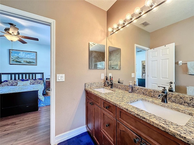 bathroom featuring a textured ceiling, wood-type flooring, vanity, and ceiling fan