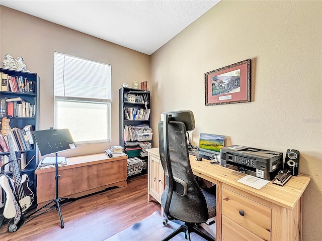 office featuring light wood-type flooring and a textured ceiling