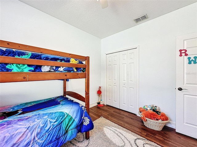 bedroom featuring a closet, ceiling fan, a textured ceiling, and dark hardwood / wood-style flooring