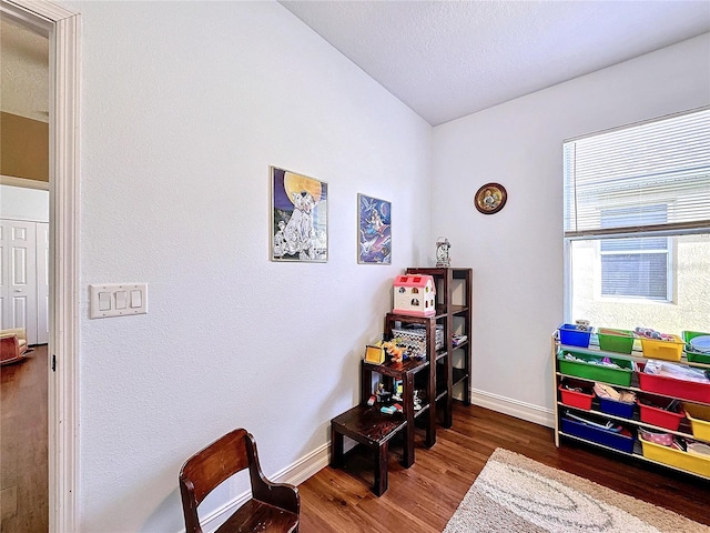 recreation room with a textured ceiling and dark hardwood / wood-style flooring