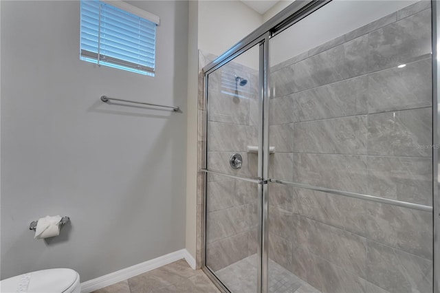 bathroom featuring toilet and a shower with door