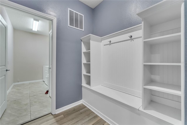 mudroom featuring a textured ceiling and light wood-type flooring