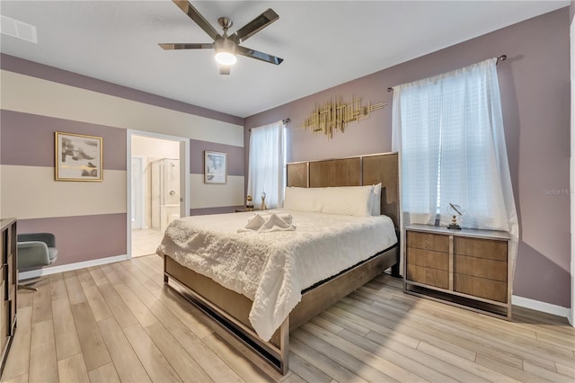 bedroom with ceiling fan, connected bathroom, and light hardwood / wood-style floors