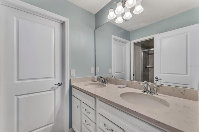 bathroom with an inviting chandelier, vanity, and an enclosed shower