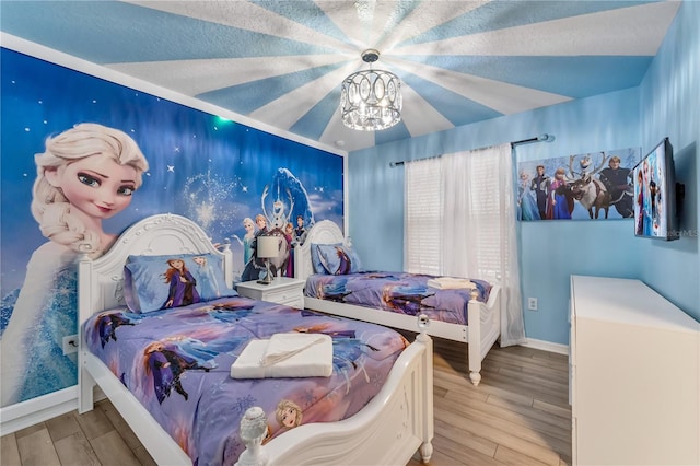 bedroom with an inviting chandelier, light wood-type flooring, a textured ceiling, and lofted ceiling