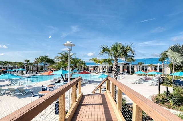 view of dock with a patio and a community pool