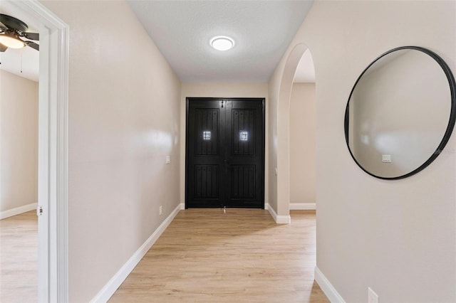 foyer entrance featuring light wood-type flooring, ceiling fan, and a textured ceiling