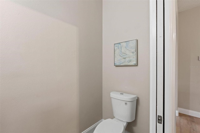 bathroom featuring hardwood / wood-style floors and toilet