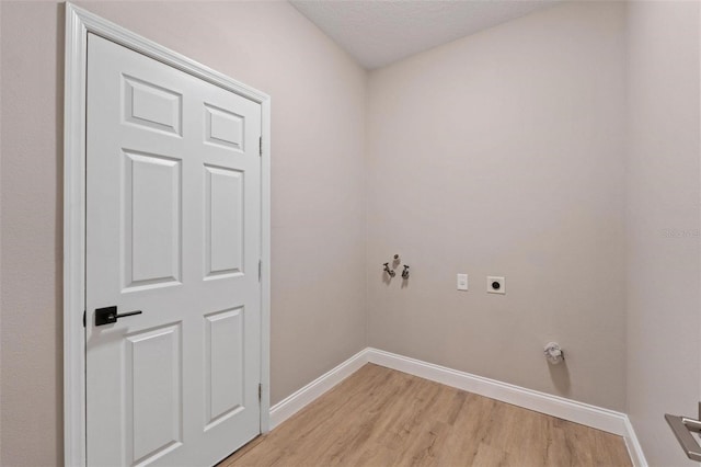 washroom featuring washer hookup, a textured ceiling, light wood-type flooring, and electric dryer hookup