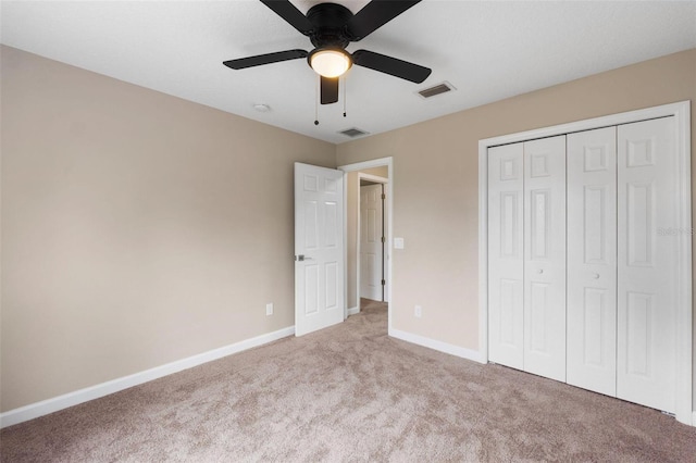 unfurnished bedroom featuring light carpet, ceiling fan, and a closet