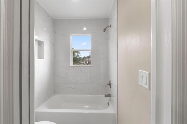 bathroom featuring tiled shower / bath and toilet