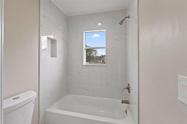 bathroom featuring toilet and tiled shower / bath