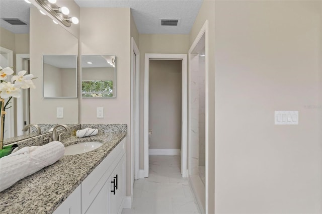 bathroom featuring a textured ceiling and vanity