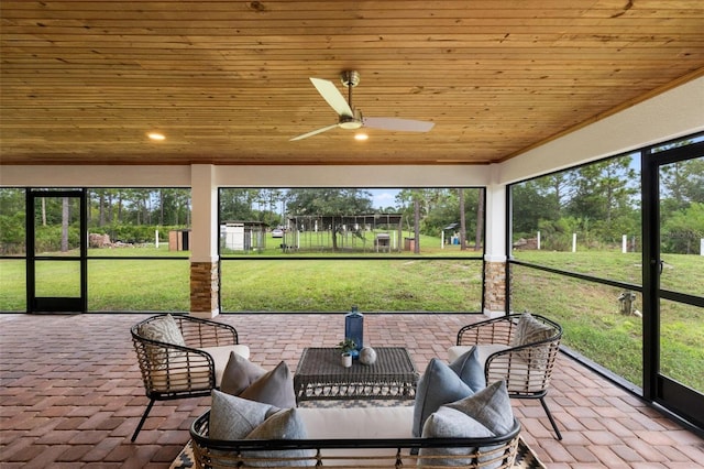 sunroom / solarium featuring ceiling fan, wood ceiling, and a healthy amount of sunlight