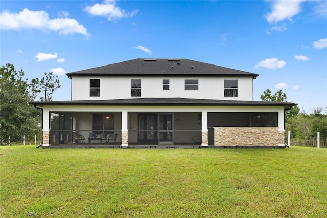 rear view of property with a sunroom and a yard