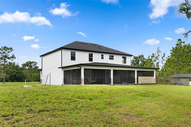 rear view of property with a yard and a sunroom