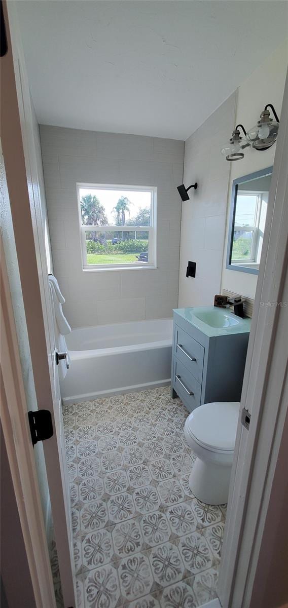 full bathroom with vanity, toilet, and tiled shower / bath combo