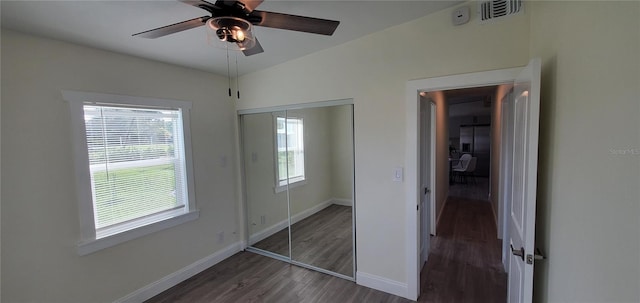 unfurnished bedroom featuring ceiling fan, dark hardwood / wood-style floors, and a closet