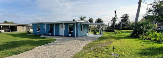 view of front of property featuring a front yard and a carport