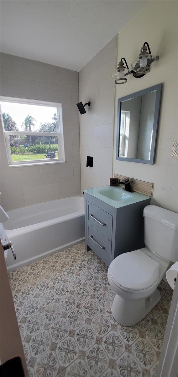 full bathroom featuring toilet, vanity, and tiled shower / bath combo