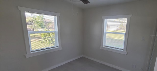 spare room with a healthy amount of sunlight, baseboards, and a ceiling fan