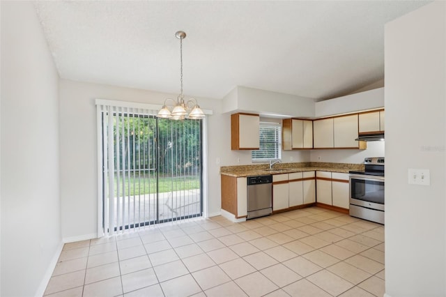 kitchen with hanging light fixtures, light tile patterned floors, stainless steel appliances, cream cabinets, and sink