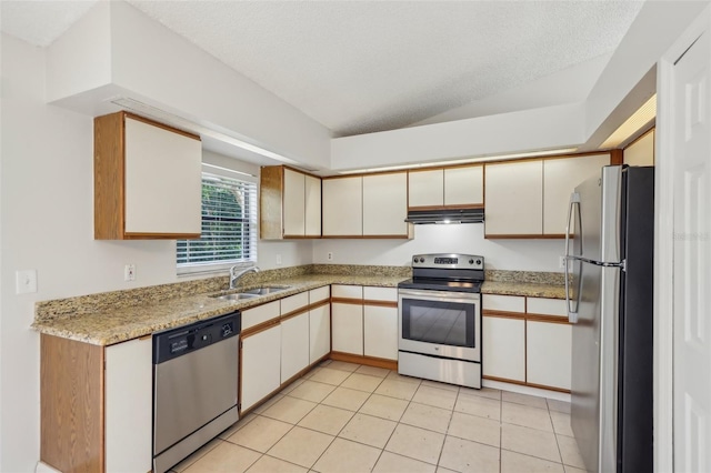 kitchen featuring a textured ceiling, light tile patterned flooring, sink, lofted ceiling, and stainless steel appliances