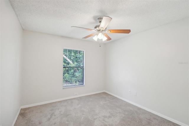 carpeted spare room featuring a textured ceiling and ceiling fan