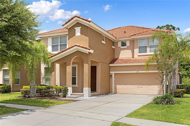 mediterranean / spanish-style house featuring a garage and a front yard