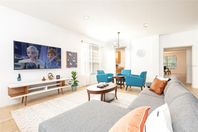 tiled living room featuring a textured ceiling and an inviting chandelier